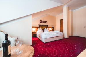 a hotel room with a bed and a bottle of wine at Cella Central Historic Boutique Hotel in Zell am See