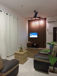a living room with a couch and a flat screen tv at Reco Villa Private Pool 4 Bedrooms@ Taman Mayung Teluk Kemang Port Dickson in Port Dickson