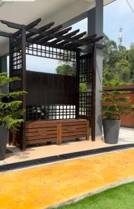 a wooden bench on a patio with two potted plants at Reco Villa Private Pool 4 Bedrooms@ Taman Mayung Teluk Kemang Port Dickson in Port Dickson