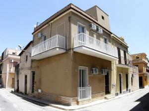 Sikelia holiday house في روسوليني: مبنى اصفر بشرفات بيضاء على شارع