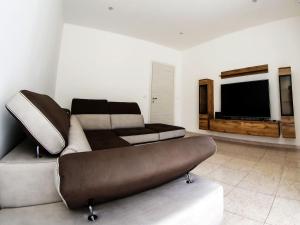 Sikelia holiday house في روسوليني: غرفة معيشة مع أريكة وتلفزيون بشاشة مسطحة