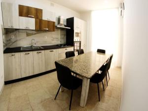 Sikelia holiday house في روسوليني: مطبخ مع طاولة وكراسي في مطبخ