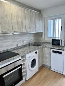 een keuken met een wasmachine en een vaatwasser bij Ducado 13 Playa Benidorm in Benidorm