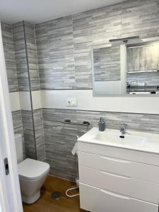 een badkamer met een witte wastafel en een toilet bij Ducado 13 Playa Benidorm in Benidorm