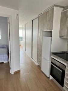 a kitchen with stainless steel cabinets and a refrigerator at Paradise Ducado Benidorm Vistas al Mar, Piscina, Parking Gratis y Wifi 4 Persona in Benidorm
