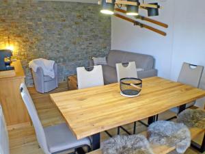 - une table à manger avec des chaises et une table en bois dans l'établissement Appartement Samoëns, 2 pièces, 4 personnes - FR-1-629-127, à Samoëns