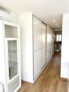 a row of white wardrobes in a room with wood floors at Paradise Ducado Benidorm Vistas al Mar, Piscina, Parking Gratis y Wifi 4 Persona in Benidorm +28 photos