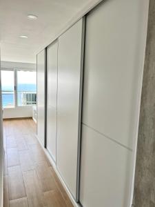 a sliding glass door in a hallway with a view of the ocean at Paradise Ducado Benidorm Vistas al Mar, Piscina, Parking Gratis y Wifi 4 Persona in Benidorm