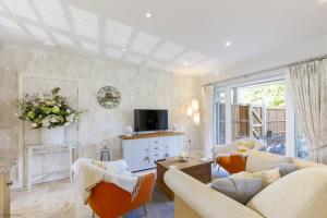 sala de estar con 2 sofás y TV en Mayaro Cottage by Inspire Stays, en Eastergate
