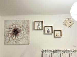 un mur avec trois cadres d'images et une fleur sur lui dans l'établissement TARANTA HOUSE - Notte della Taranta casa con giardino, à Melpignano