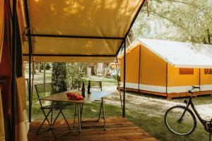 una mesa frente a una tienda con bicicleta en Camping Onlycamp Domelin en Beaufort