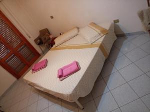 1 dormitorio con 1 cama con 2 almohadas rosas en Appartamento Santa Giusta, en Santa Giusta