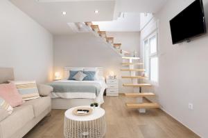 een witte woonkamer met een bed en een trap bij Apartamento La Fuente in Vejer de la Frontera