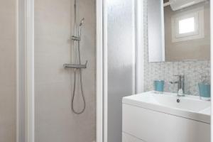 een witte badkamer met douche en wastafel bij Apartamento La Fuente in Vejer de la Frontera +13 foto's