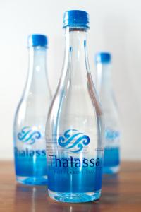three bottles of water sitting on a wooden table at Thalassa - SHA Plus in Koh Tao