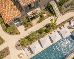 an overhead view of a pool with tables and umbrellas at Hôtel L'Escalet in Ramatuelle