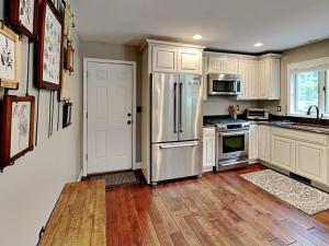 a kitchen with white cabinets and a stainless steel refrigerator at Yes Deer in Oakland