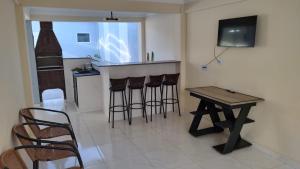 una cucina con tavolo e bar con sgabelli di Wana casa 1 Requinte e conforto a Sao Jose do Rio Preto