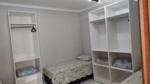 a bedroom with a bed and white shelves at Wana casa 1 Requinte e conforto in Sao Jose do Rio Preto