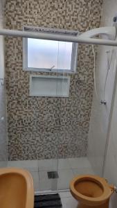 a bathroom with a toilet and a window in it at Wana casa 1 Requinte e conforto in Sao Jose do Rio Preto