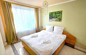 Oslip的住宿－Dreamly Suites，一间卧室配有一张带白色床单的床和一扇窗户。