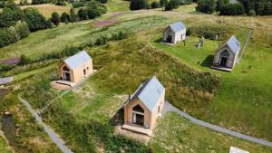 una vista aérea de tres casas pequeñas en un campo en Tarset Tor - Bothy 2, en Hexham