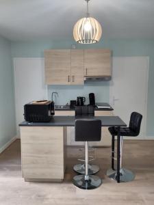 kuchnia z blatem i krzesłami w pokoju w obiekcie appartement refait à neuf pour 3 personnes avec wi-fi w mieście Vic-sur-Cère