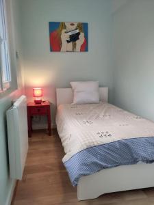 a bedroom with a bed and a table with a lamp at appartement refait à neuf pour 3 personnes avec wi-fi in Vic-sur-Cère