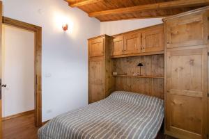 a bedroom with a bed and wooden cabinets at Estate in montagna in San Vito di Cadore