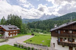 an aerial view of a house and a field with mountains at Estate in montagna in San Vito di Cadore