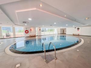 a large swimming pool in a large building at Cosmos Living Spacious Studio With Balcony in Dubai