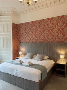 1 dormitorio con 1 cama grande con papel pintado de color rojo en Arrandale Guest House, en Edimburgo