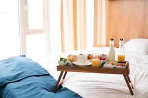 a tray of breakfast foods and drinks on a bed at Jegtvolden Fjordhotell in Straumen