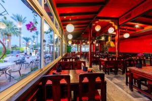 un restaurante con paredes rojas, mesas y sillas en Ghazala Beach en Sharm El Sheikh