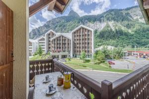 uma varanda com uma mesa e vista para um edifício em Casa Beatrice em Courmayeur