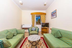 a living room with two green couches and a table at Ghazala Beach in Sharm El Sheikh