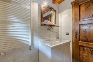 een badkamer met een wastafel en een houten deur bij CASA BEATRICE - Wifi, Parcheggio e Vista Montagna - COUR 0231 in Courmayeur +28 foto's