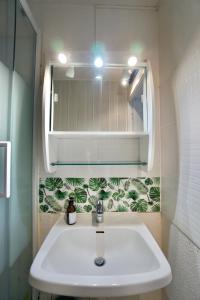 La salle de bains est pourvue d'un lavabo et d'un miroir. dans l'établissement La Lézardière *Front de mer*, à Ploemeur