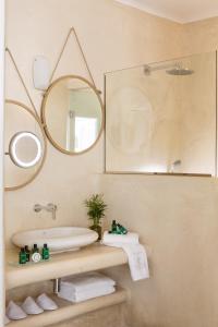 a bathroom with a sink and a mirror at Colours of Mykonos Luxury Residences & Suites in Psarou +18 photos