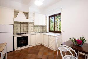 een keuken met witte kasten en een tafel en een raam bij Country Life Relais in Massa Lubrense