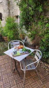 - une table et des chaises avec une assiette de fruits dans l'établissement Il Geco, à Matera