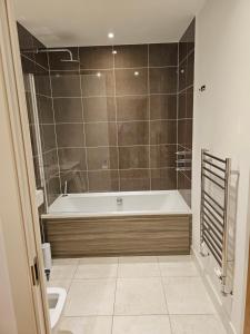 a bathroom with a bath tub and a toilet at Santina Apartments in Croydon
