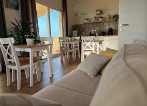 een woonkamer met een bank en een tafel en stoelen bij Ulivi di Cleo in Realmonte