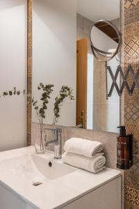 a bathroom with a sink with a mirror and towels at BNBHolder Apartamentos en Sol Confort 4 in Madrid