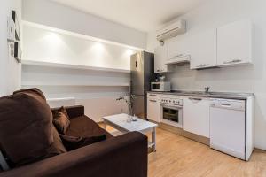ein Wohnzimmer mit einem Sofa und einer Küche in der Unterkunft BNBHolder Apartamentos en Sol Confort 4 in Madrid