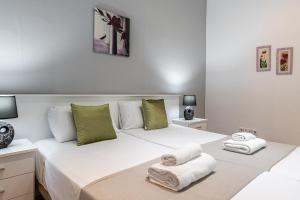 Un dormitorio con una cama blanca con toallas. en BNBHolder Apartamentos en Sol Confort 4, en Madrid