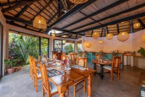 uma sala de jantar com mesas e cadeiras de madeira em Hornbill Lodge em Kariba