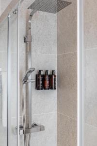 eine Dusche mit Flaschen auf einem Regal im Bad in der Unterkunft BNBHolder Apartamentos en Sol Confort 4 in Madrid
