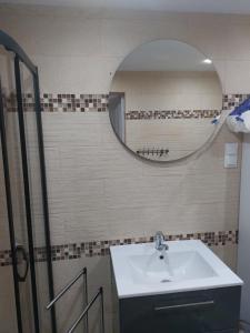 ein Bad mit einem Waschbecken und einem Spiegel in der Unterkunft Całoroczny Dom na wsi z Sauna I Jacuzzi in Płużnica