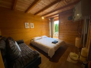 a bedroom with a bed and a couch in a room at Viridian Three Boathouse Micah, PERUCAC LAKE in Perućac